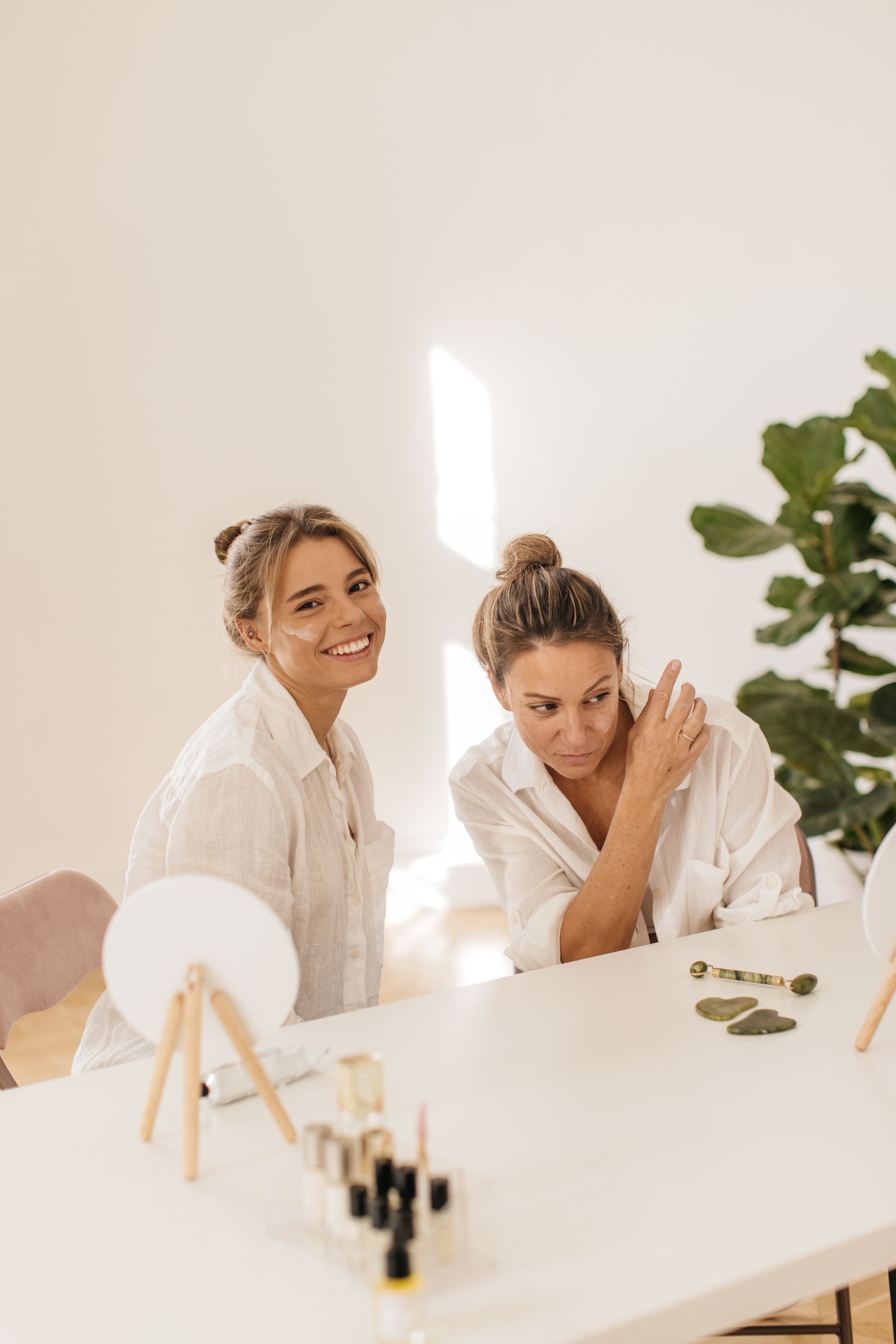 Two women are sitting at a table looking at each other.