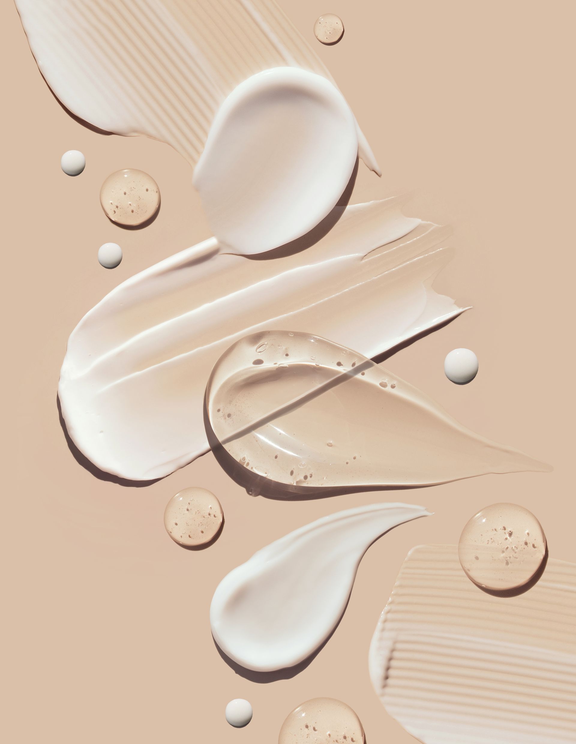 A close up of different types of cream on a beige background
