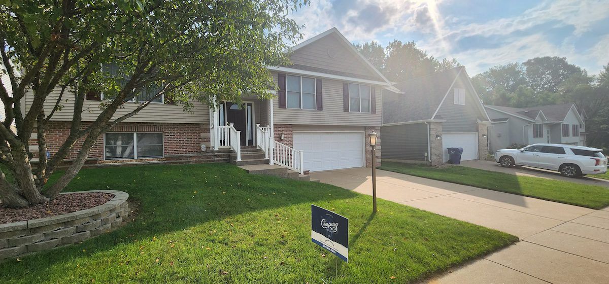 A house with a for sale sign in front of it.