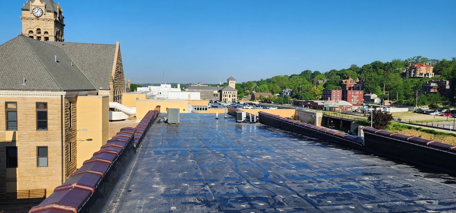 A rooftop view of a city with a clock tower in the background