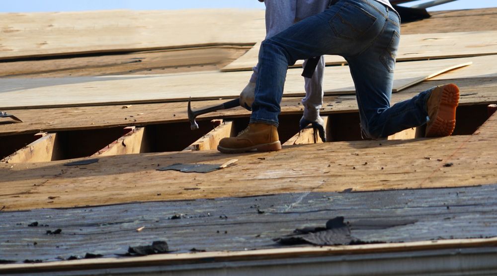 Worker Kneeling on a Rooftop — SRV Roofing in Hervey Bay, QLD