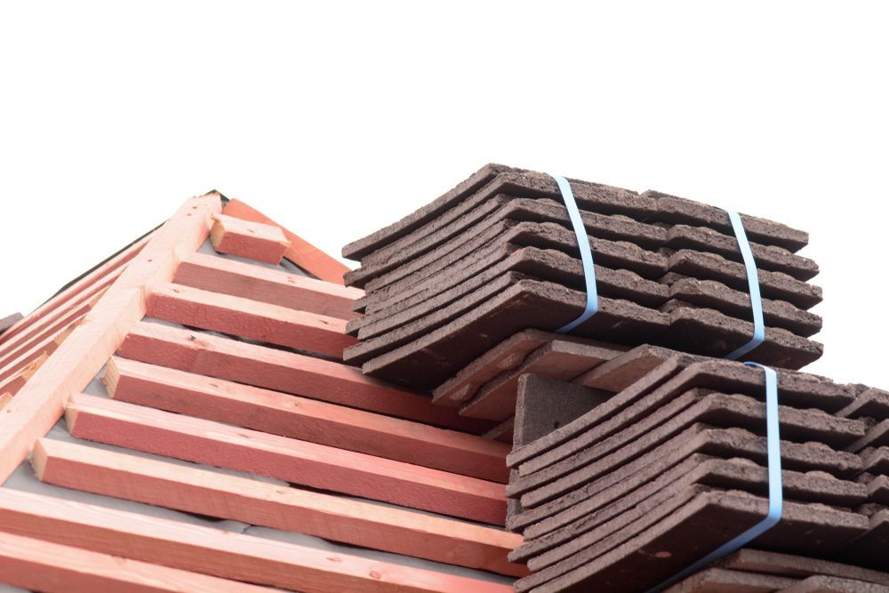 A Stack Of Tiles Sitting On Top Of A Roof — SRV Roofing in Maroochy River, QLD