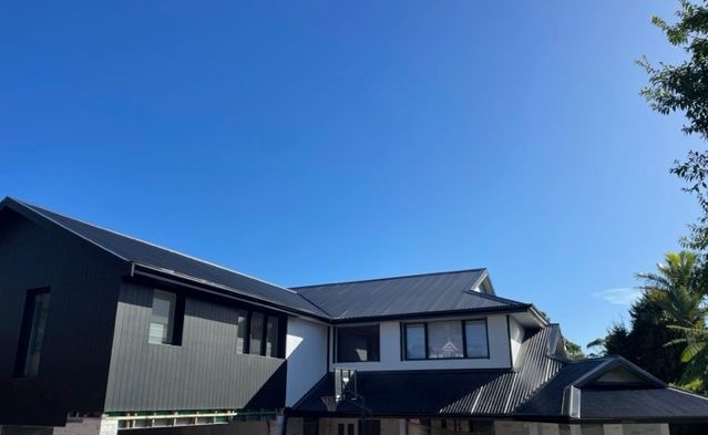 A Large House With A Black Roof — Expert Roofers in Maroochy River, QLD