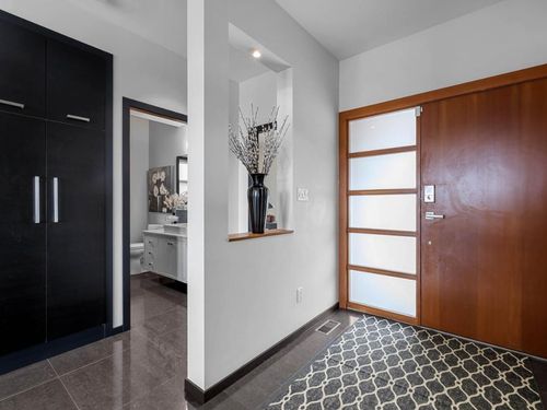 A hallway in a house with a wooden door and a rug on the floor.