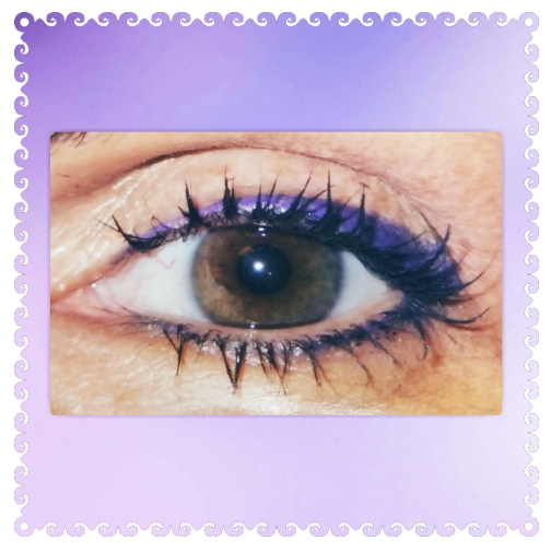 Close-up of an eye with brown iris, dark eyelashes, and purple eyeliner.
