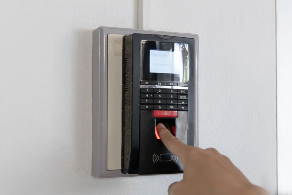 A person is pressing a button on a fingerprint scanner.