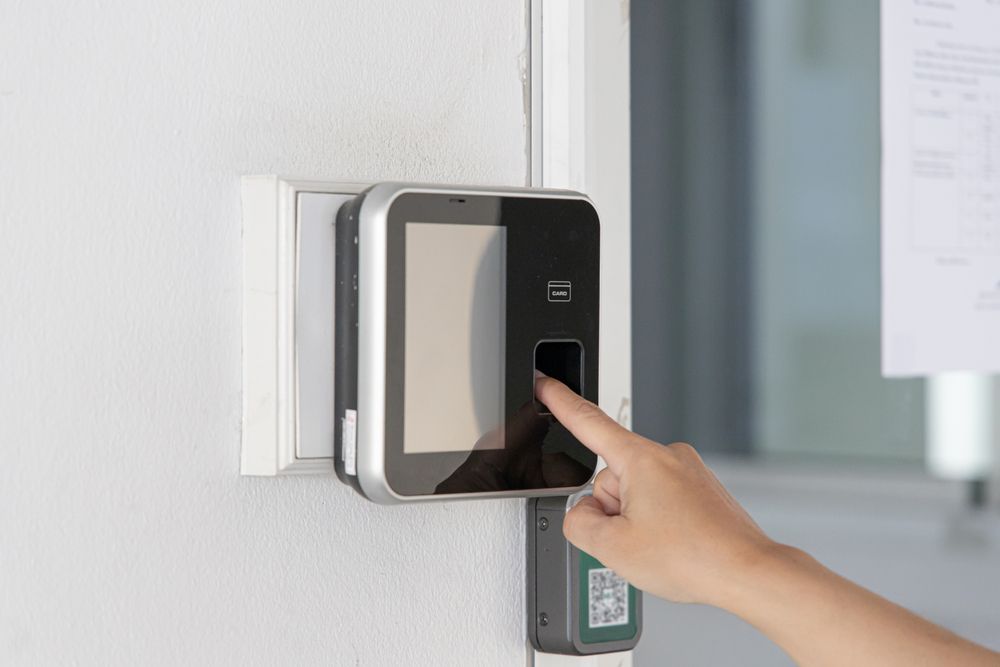 A person is using a fingerprint scanner to open a door.