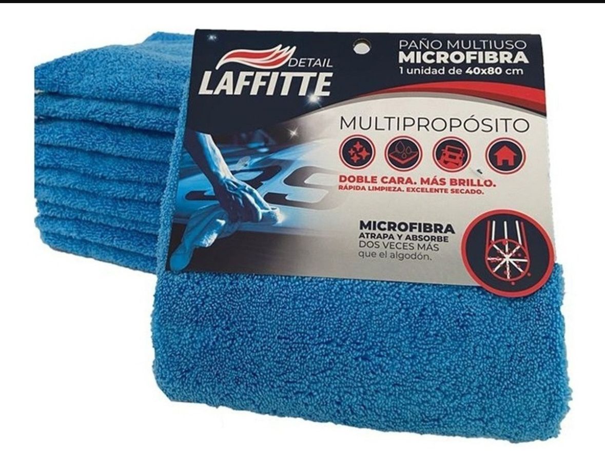 Paño de limpieza de microfibra azul, doblado cuidadosamente sobre una superficie blanca.