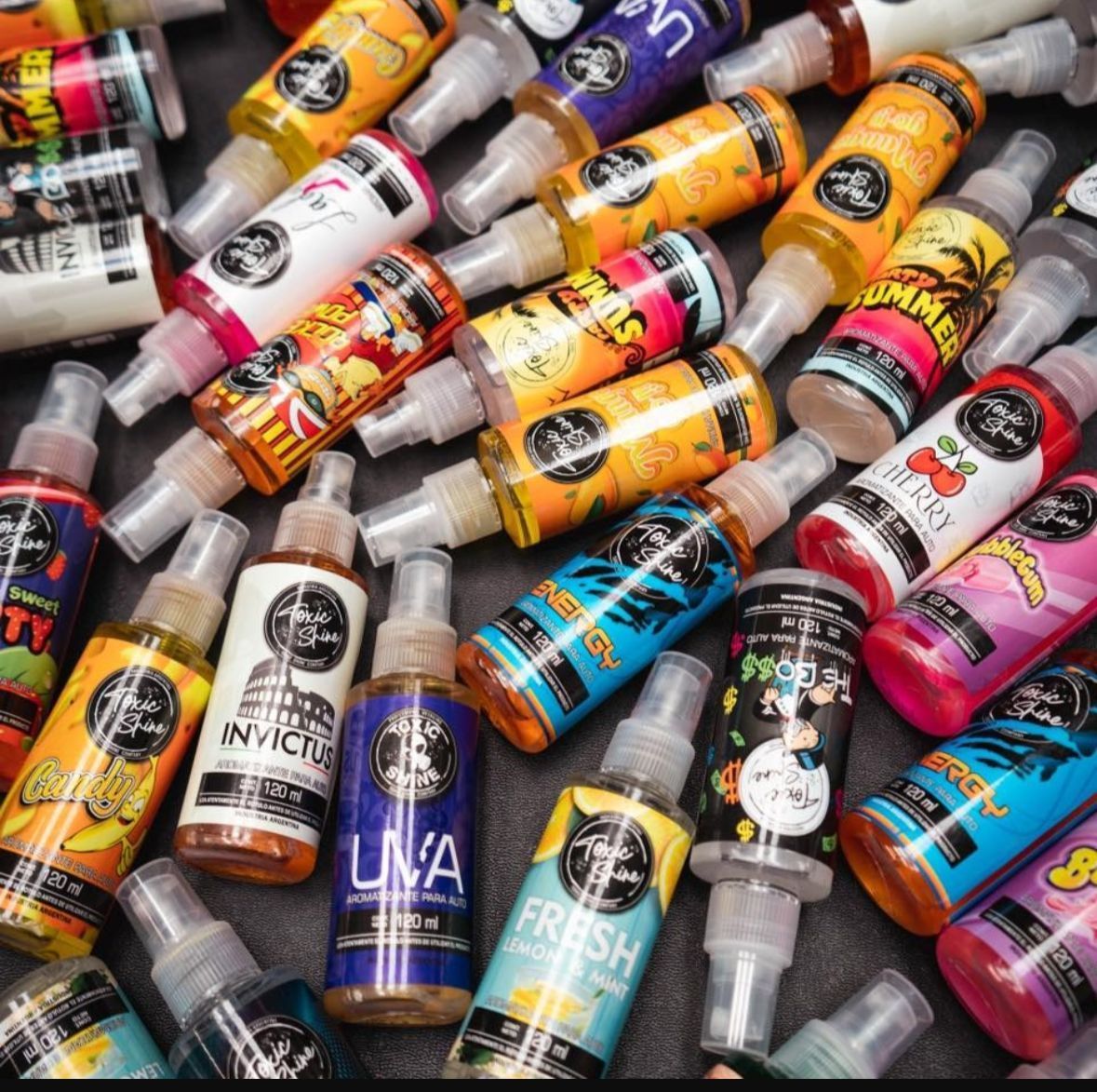 Botellas de spray líquidos de distintos sabores con etiquetas de colores, colocadas juntas sobre una superficie.