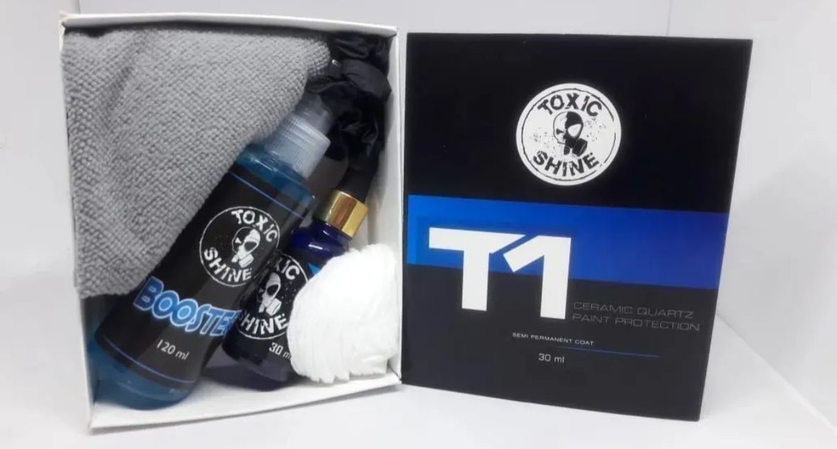 Caja con productos para el detallado del coche: botellas azules, aplicador blanco, paño gris y caja negra.