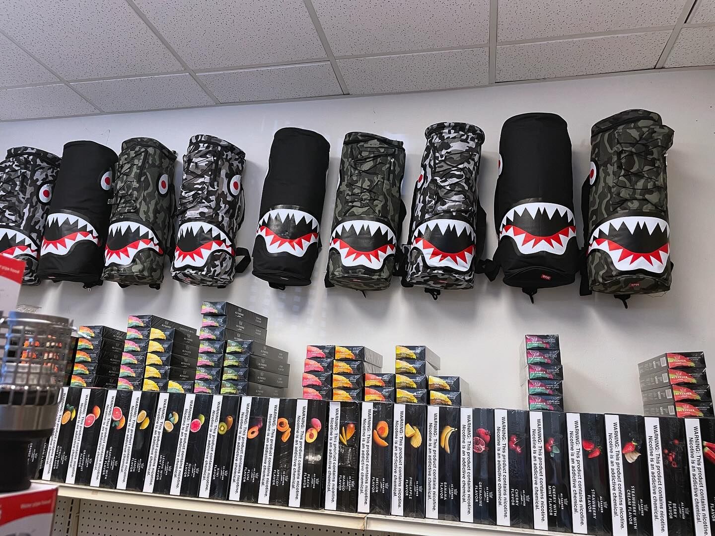 Golf club head covers with shark mouths on display in a store.