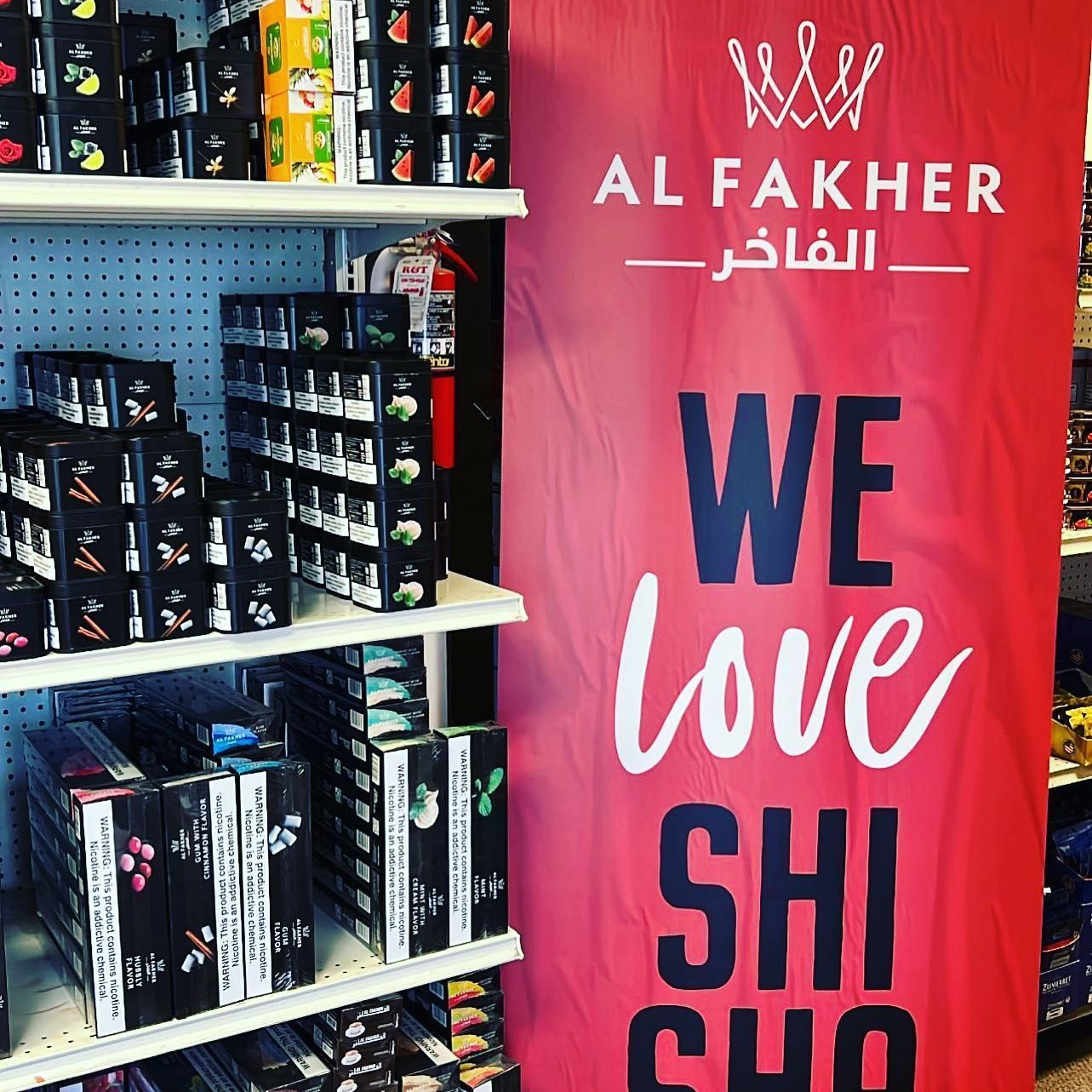 Shelves of Al Fakher hookah tobacco with a red banner that reads 