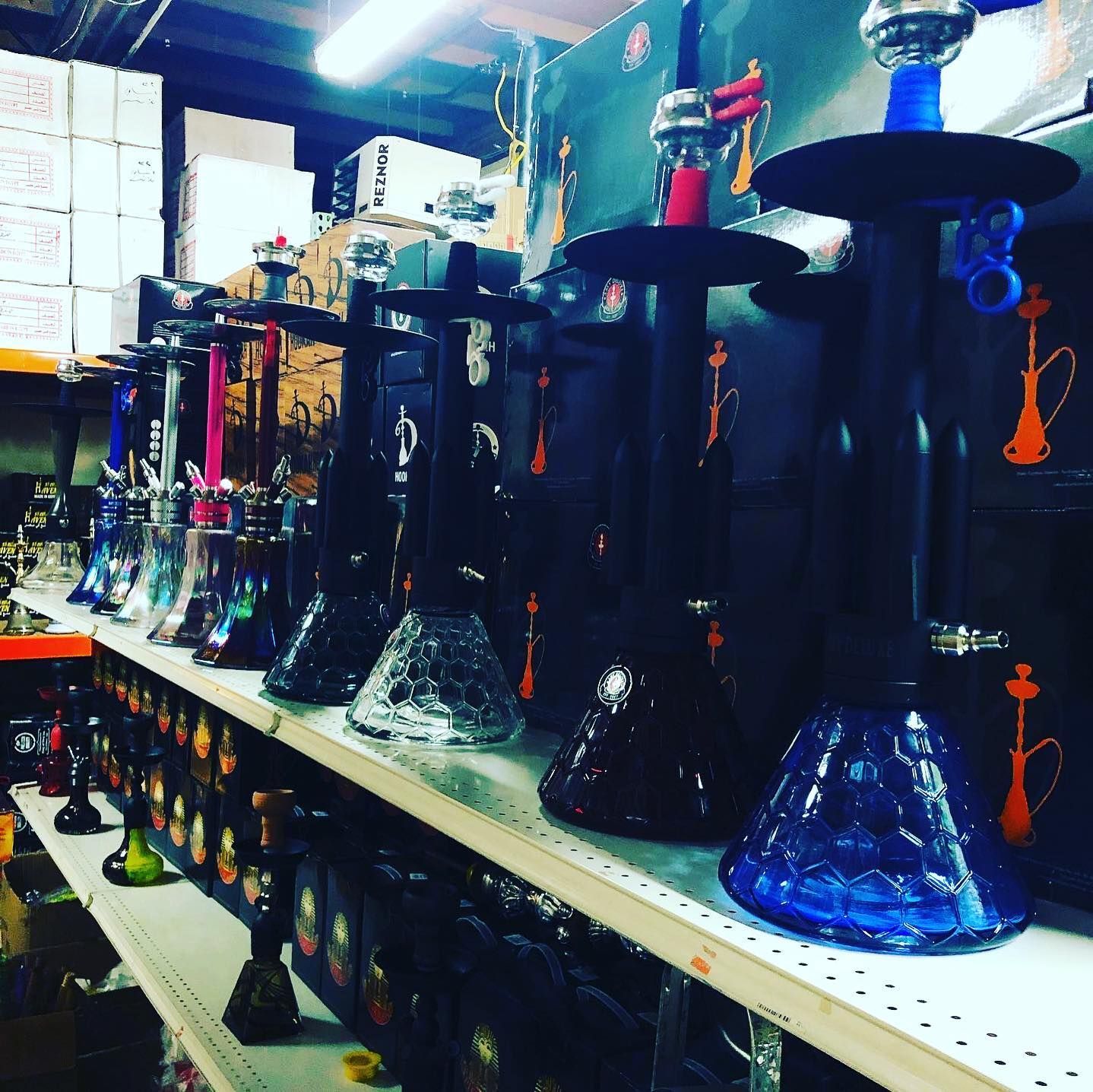 A shelf displaying a variety of colorful hookahs in a shop setting.