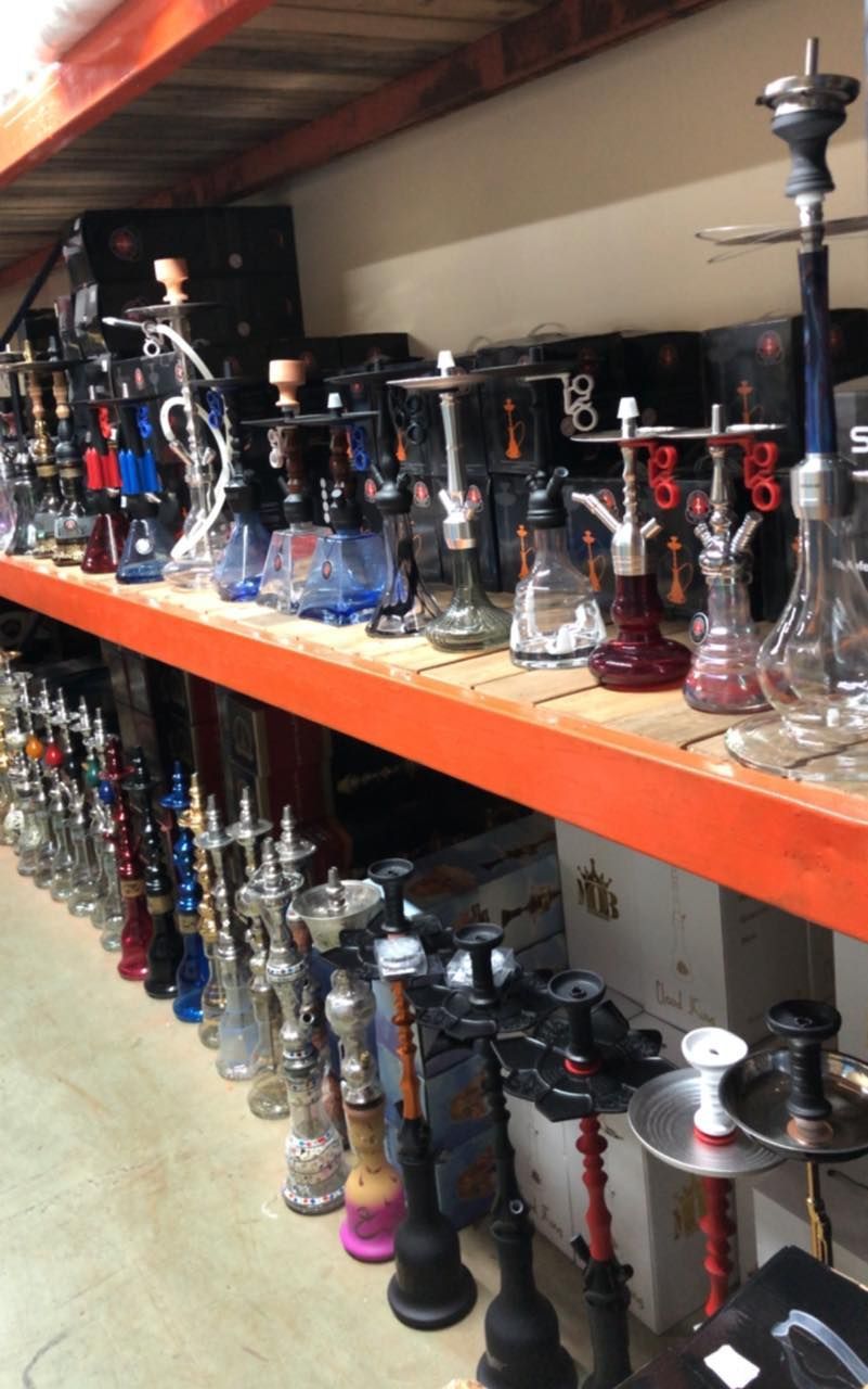 Rows of hookahs displayed on shelves in a store.