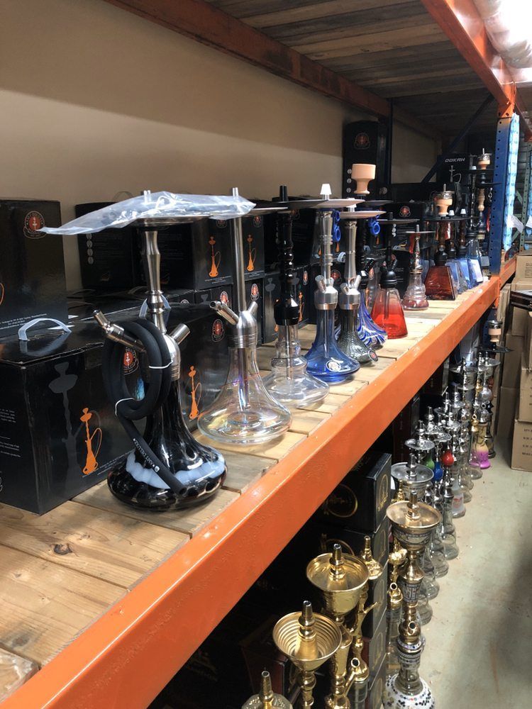 Shelves filled with various hookahs in a store setting.