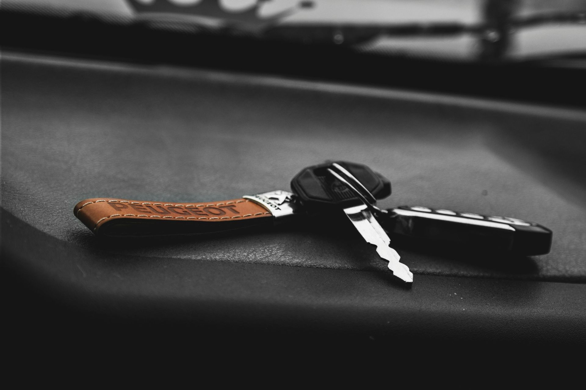 A pair of car keys are sitting on the dashboard of a car.