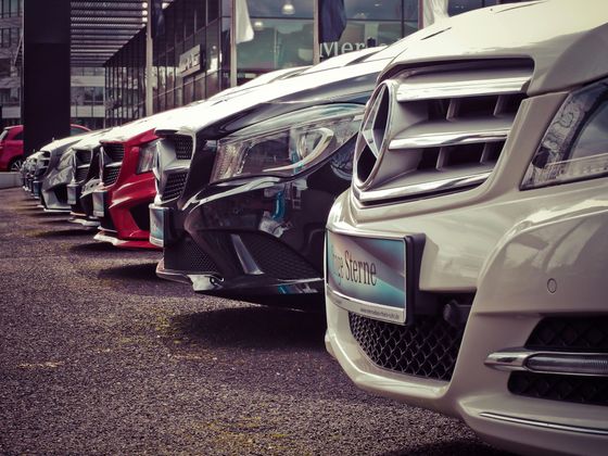 A row of cars are parked next to each other in a parking lot.