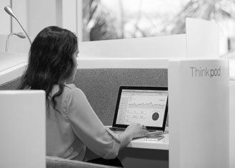a woman is sitting at a desk using a laptop computer .