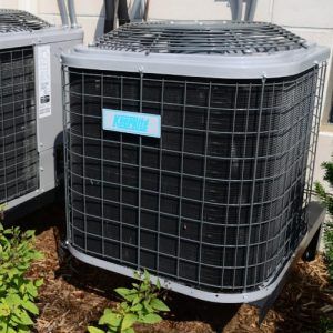 Two air conditioners are sitting next to each other on the side of a building.