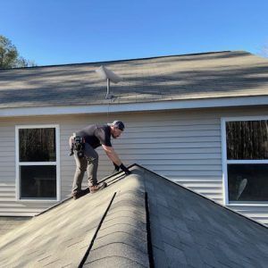 A man is working on the roof of a house.