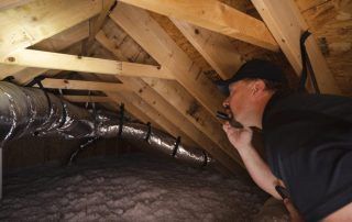 A man is looking through a hole in the ceiling of a house.