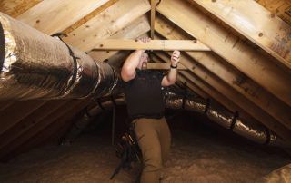 A man is working in the attic of a house.