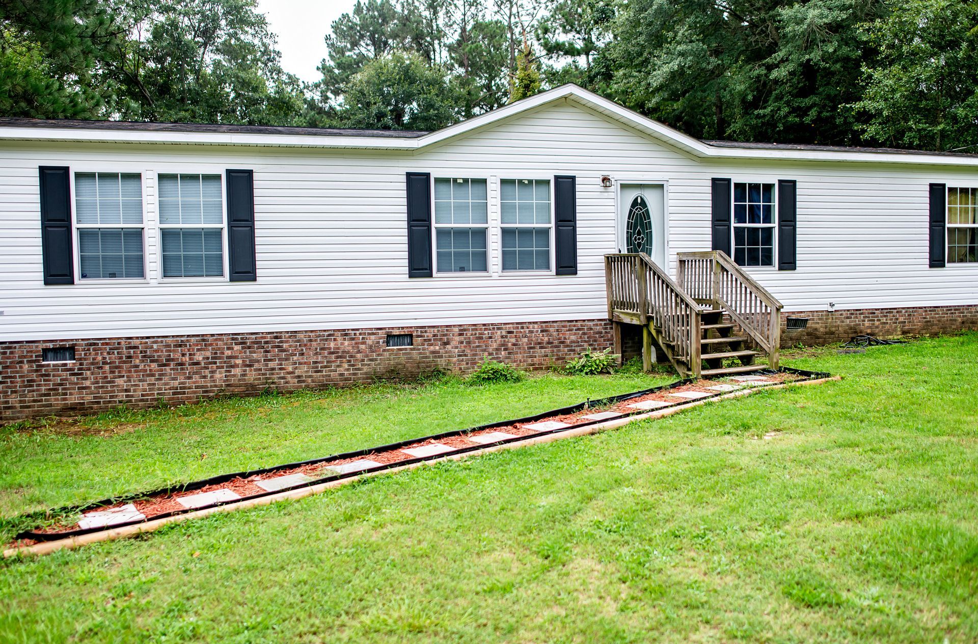 A man is standing on a ladder on the side of a house.