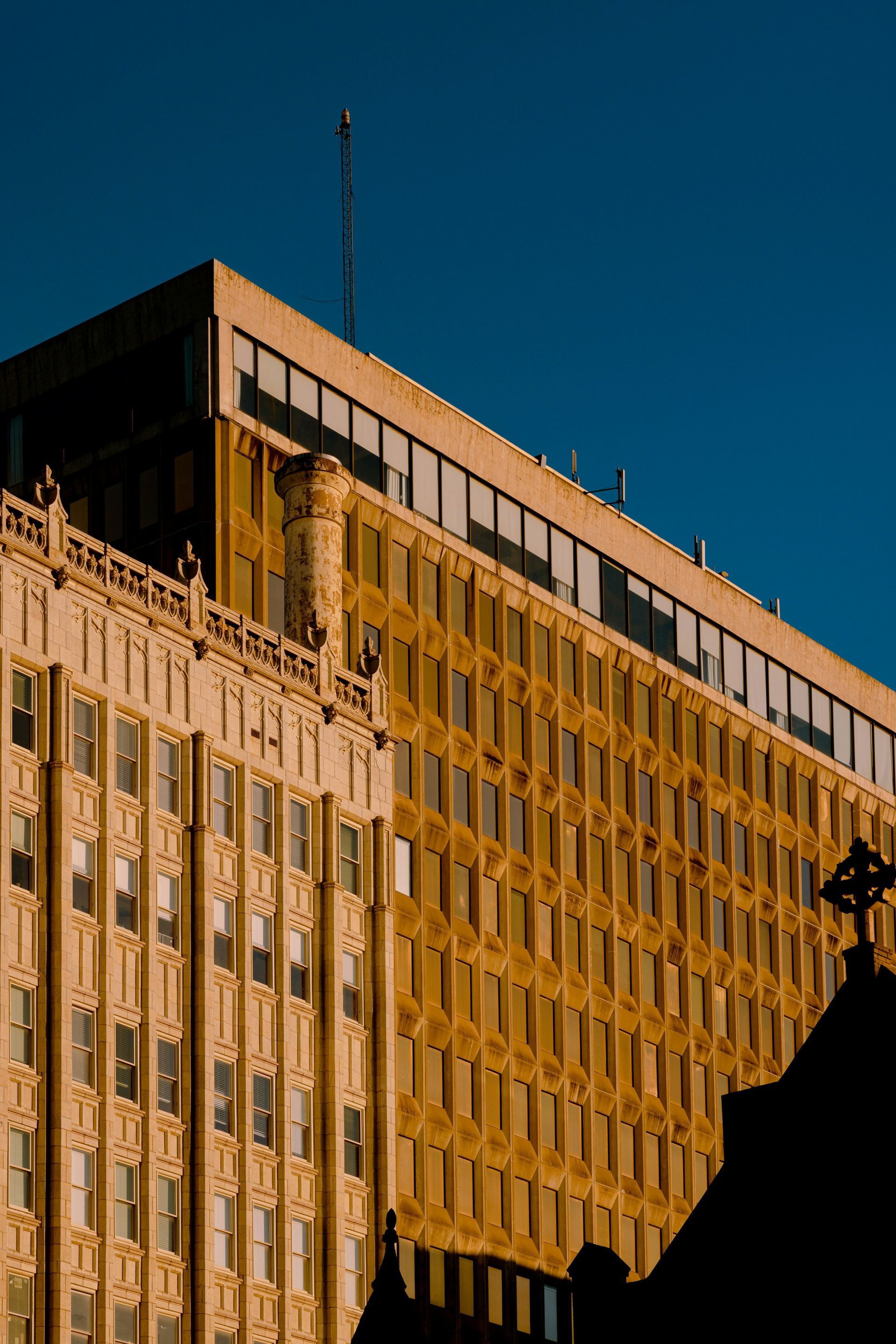 A large building with a lot of windows and a blue sky in the background.