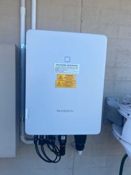 A White Box With a Yellow Sticker on It is Hanging on a Wall — JW Electrical, Air & Solar Pty Ltd in Kew, NSW