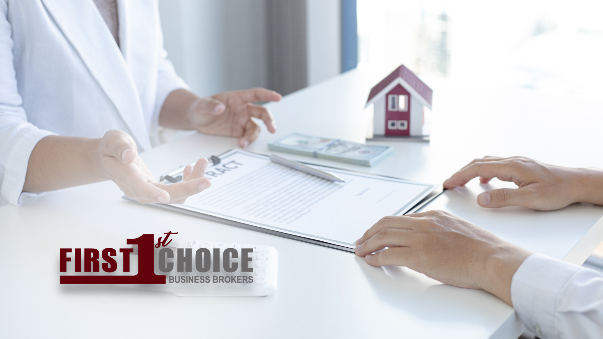 A woman is sitting at a table talking to a man about a house.