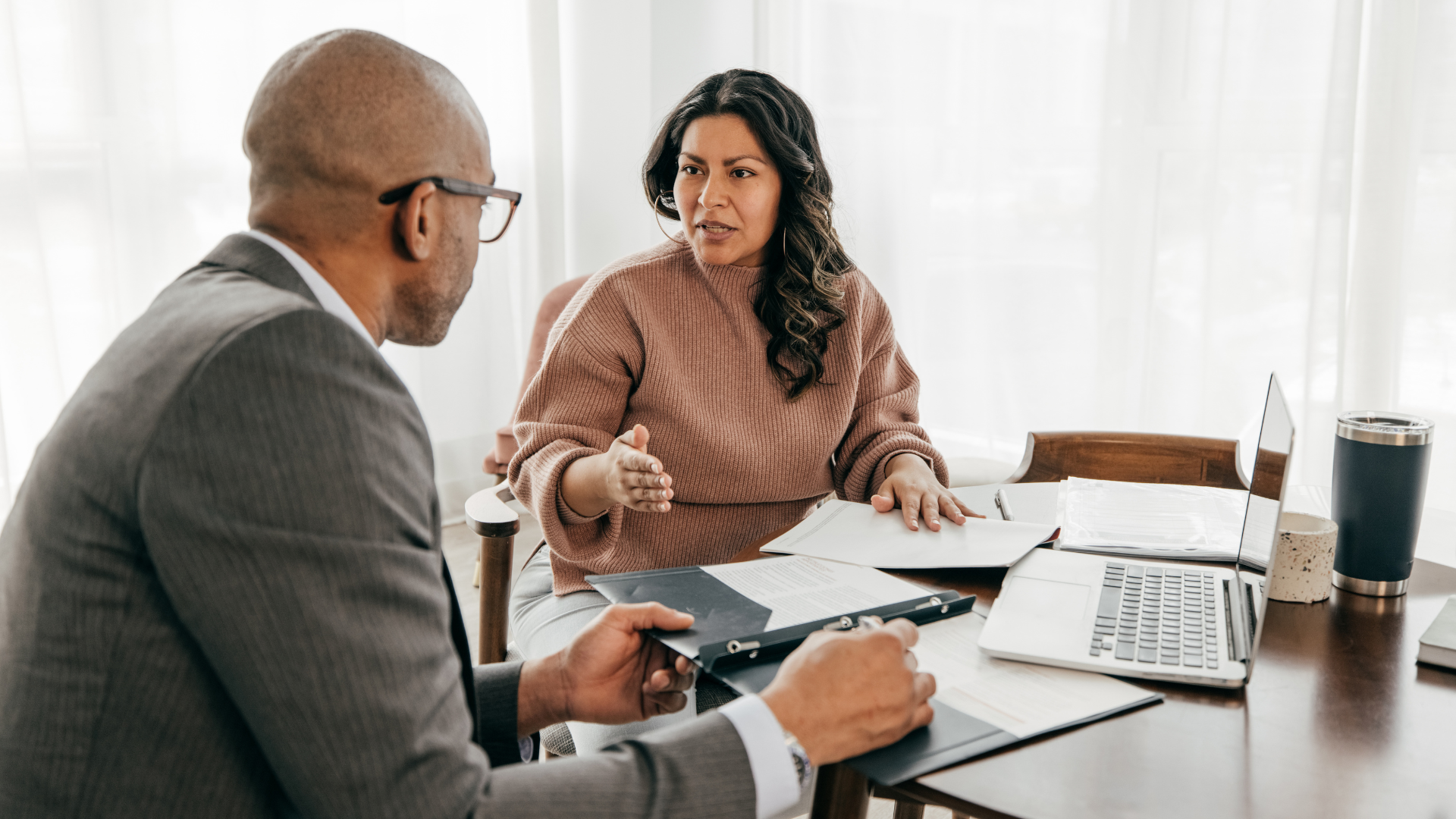 A man and a woman are sitting at a table having a conversation.