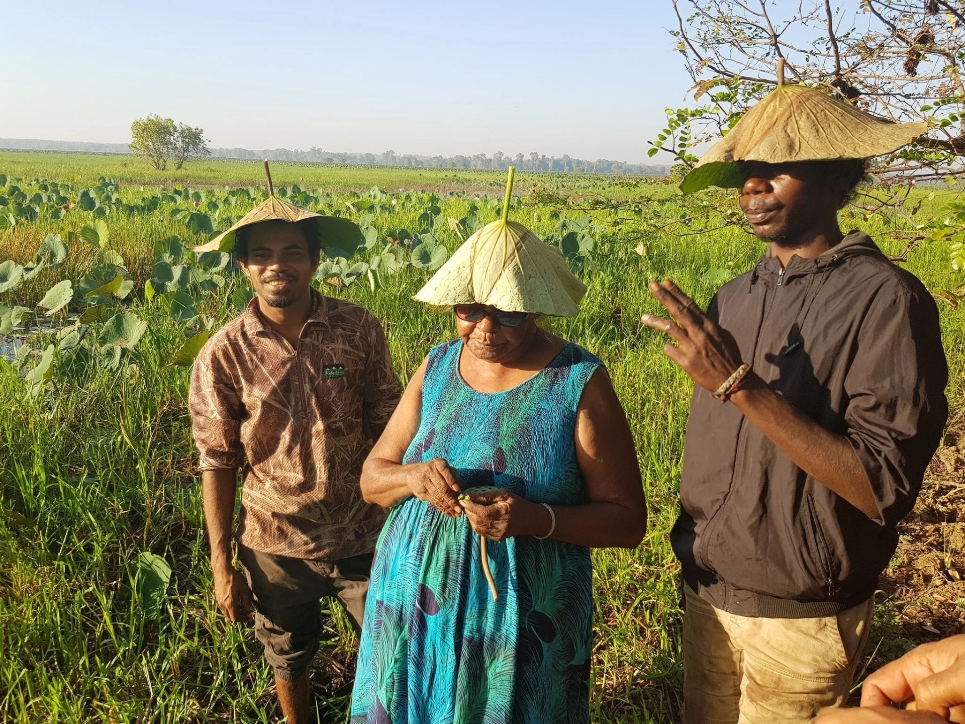 Three People Wearing Leaf Hats Stand in A Marshy Area — Kakadu Billabong Safari Camp In Kakadu, NT