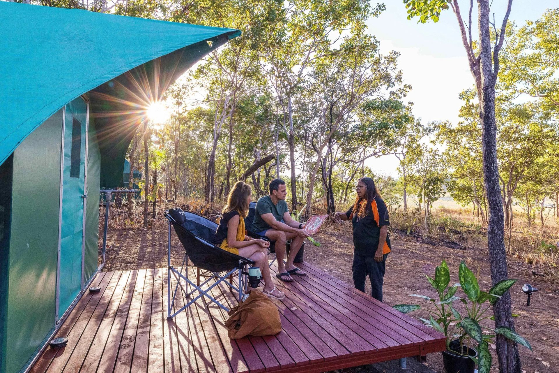 Couple on A Wooden Deck, Talking with A Person — Kakadu Billabong Safari Camp In Kakadu, NT