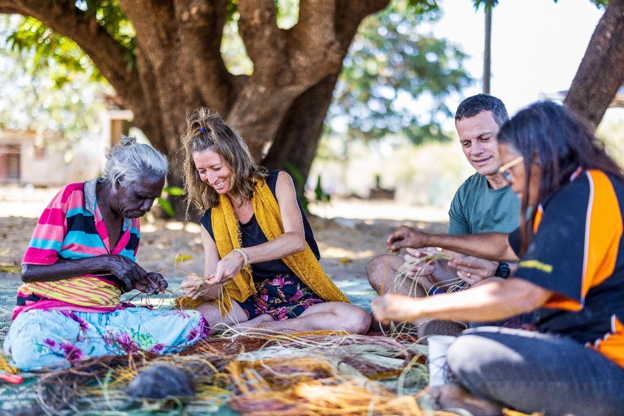 People sitting under a tree weaving natural fibers together outdoors — Kakadu Billabong Safari Camp in Kakadu, NT