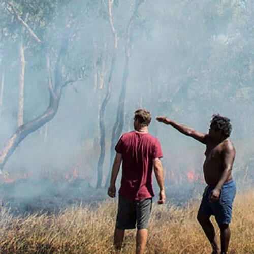 Two Men in Smoky Forest One Points Toward Burning Grass — Kakadu Billabong Safari Camp In Kakadu, NT