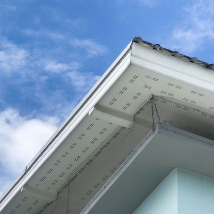 The roof of a house with a blue sky in the background.