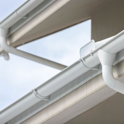 A close-up of a white gutter on a roof.