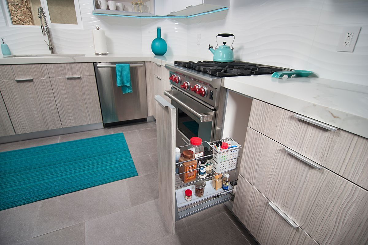 Modern kitchen with beige cabinets, stainless steel appliances, turquoise accents.