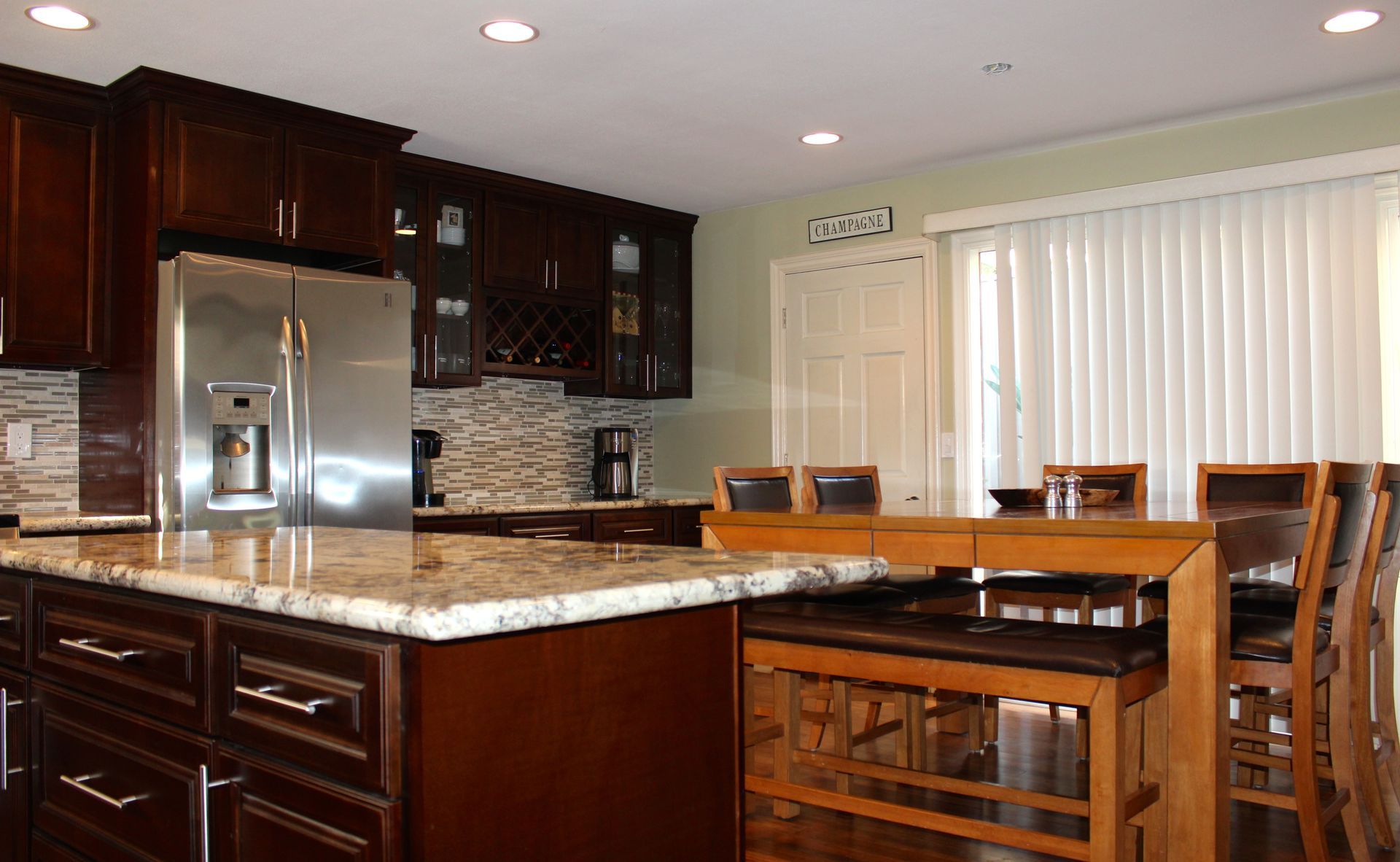 Dark wood kitchen with granite countertops, stainless steel appliances, and a breakfast bar.