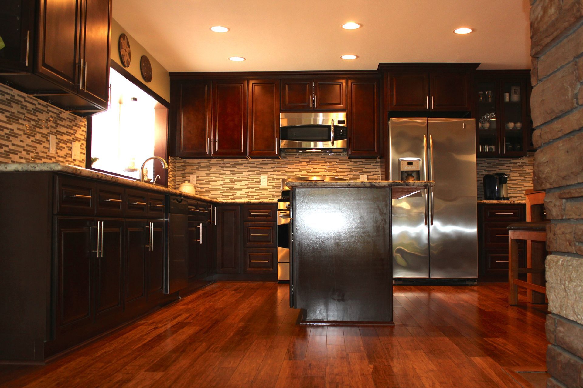 Dark wood kitchen with stainless steel appliances and island.
