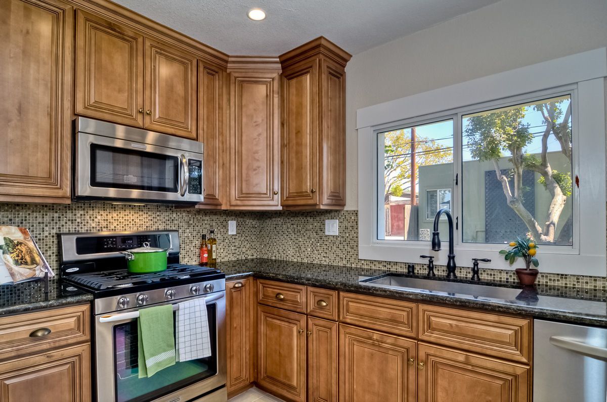 Kitchen corner with wooden cabinets, stainless steel appliances, and a sink.
