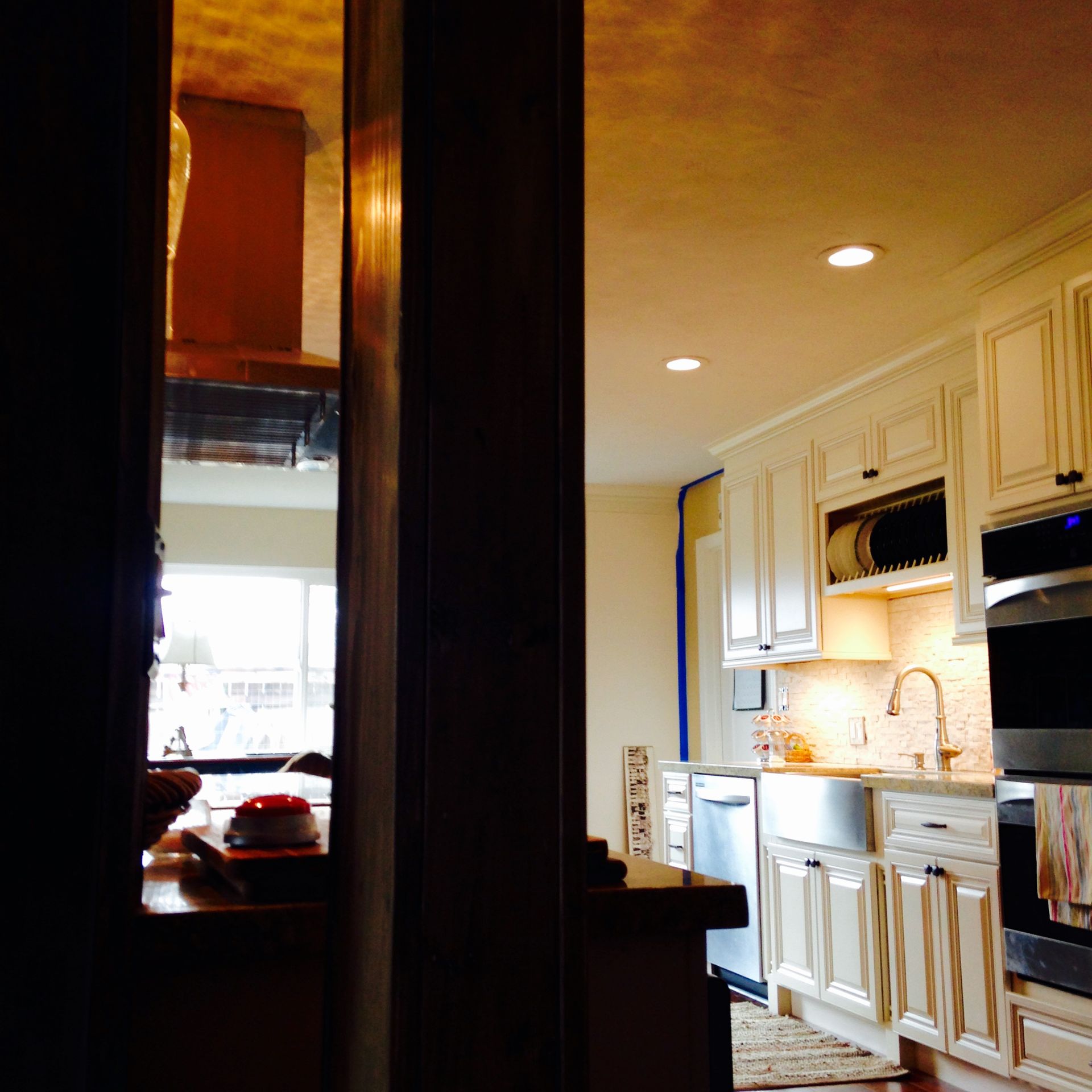 Kitchen interior with white cabinets, stainless steel appliances, and a view through a doorway.