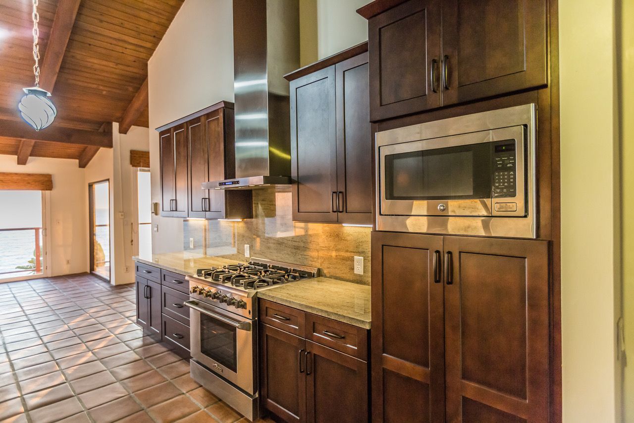 Kitchen with dark wood cabinets, stainless steel appliances, and granite countertops.