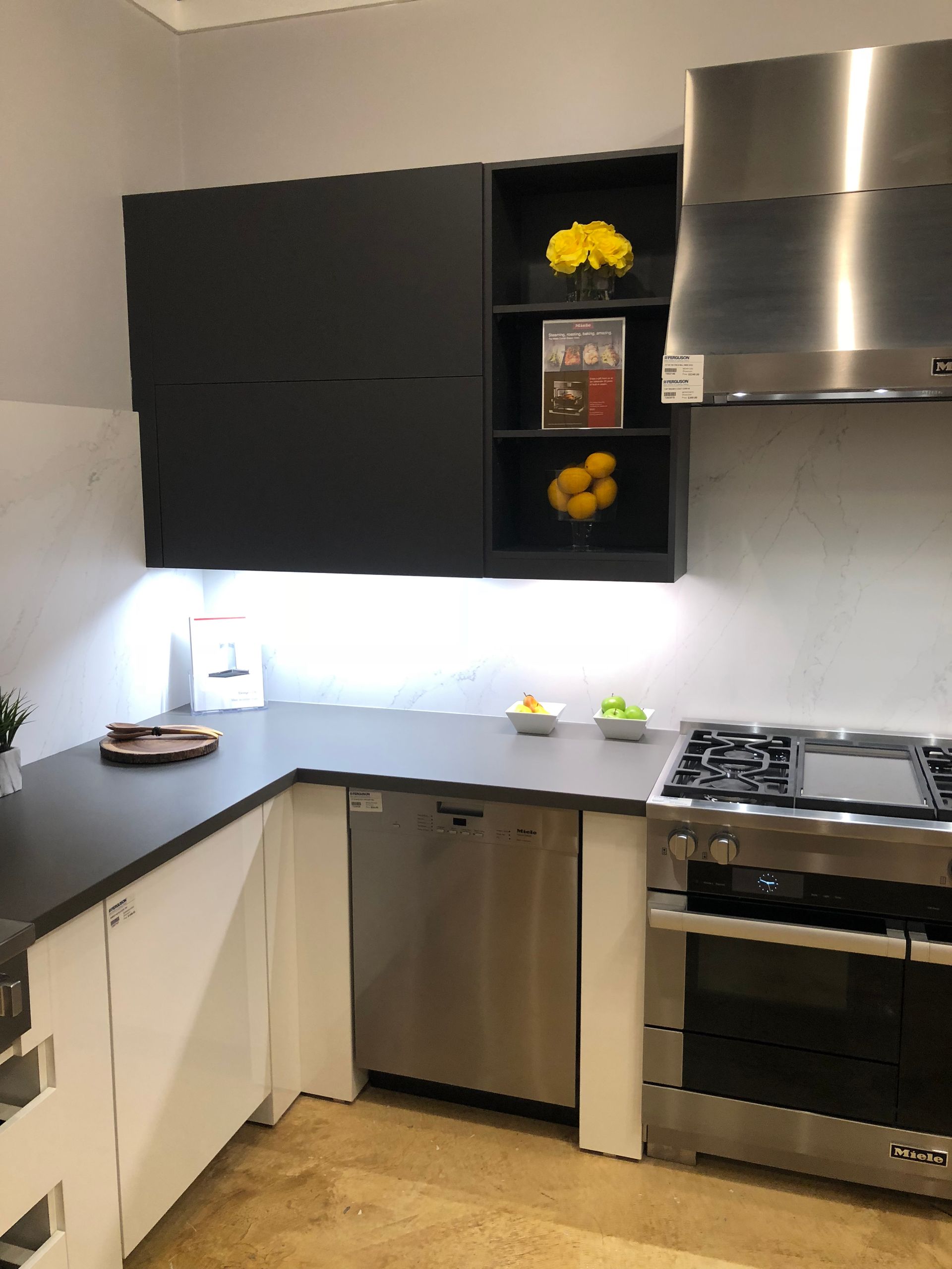 Modern kitchen with dark gray cabinets, stainless steel appliances, and countertop.