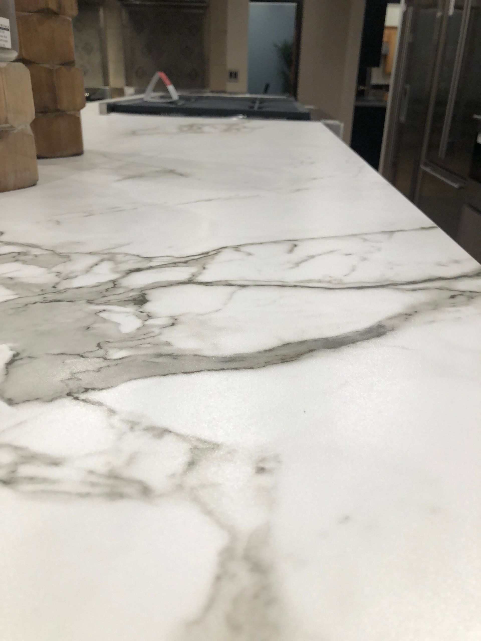 White countertop with gray veining; kitchen setting.