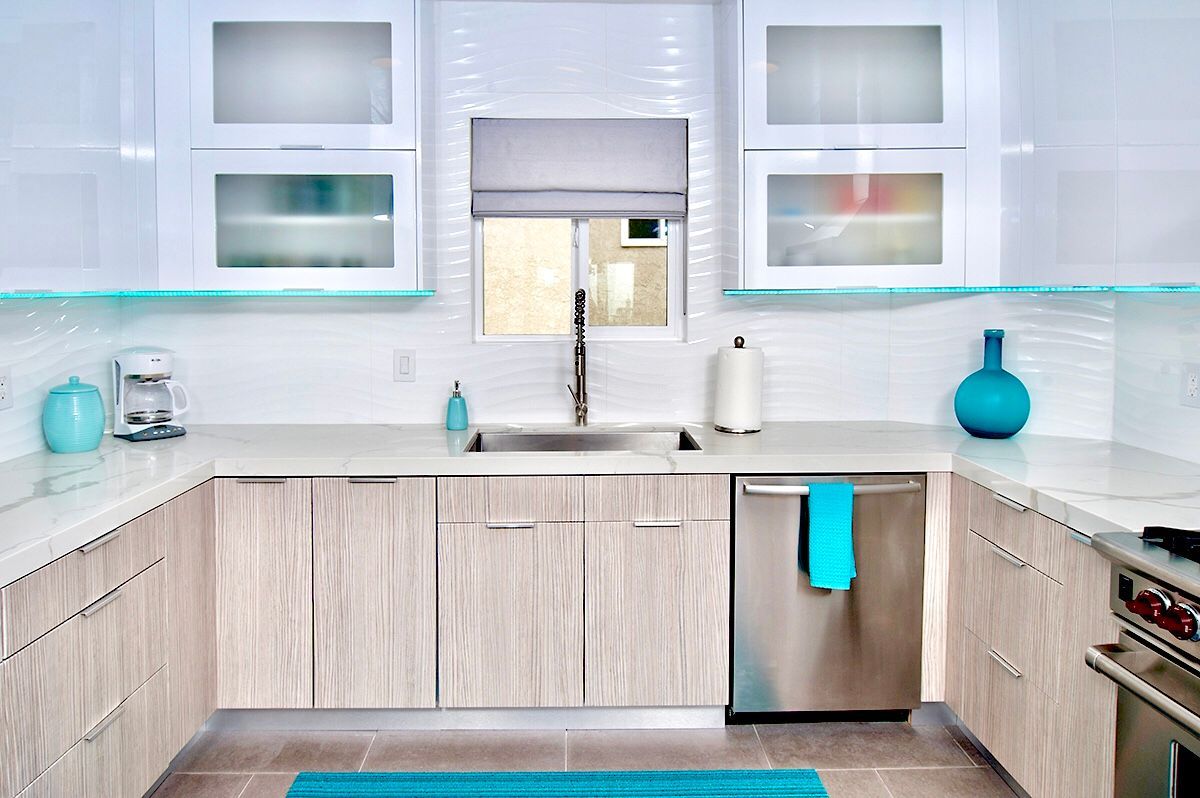 Modern, bright kitchen with white cabinets, stainless steel appliances, and turquoise accents.