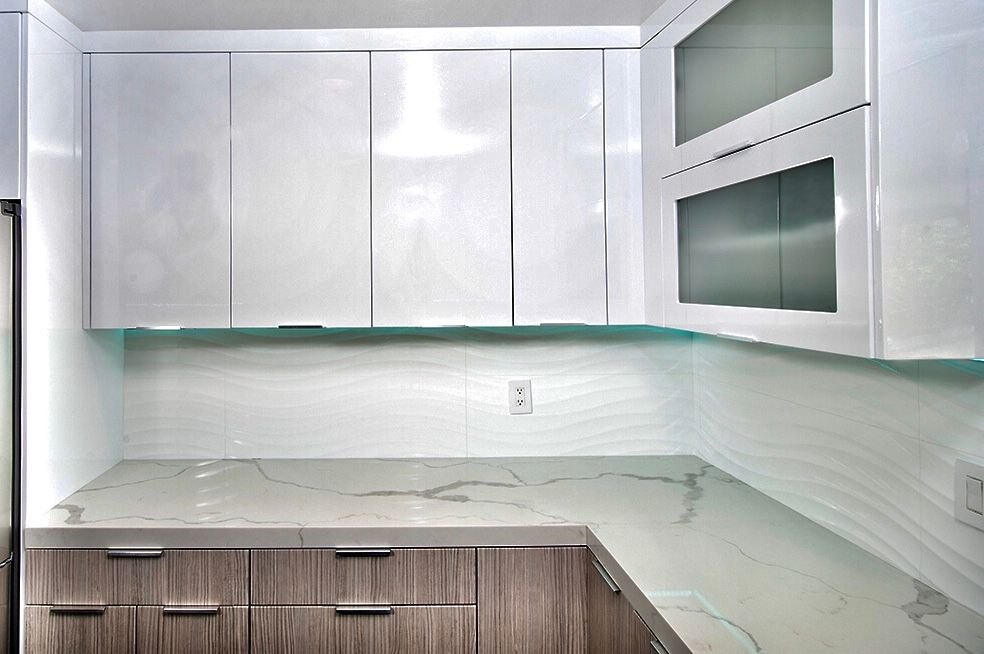Modern kitchen with white glossy cabinets, marble countertop, and wood lower cabinets.