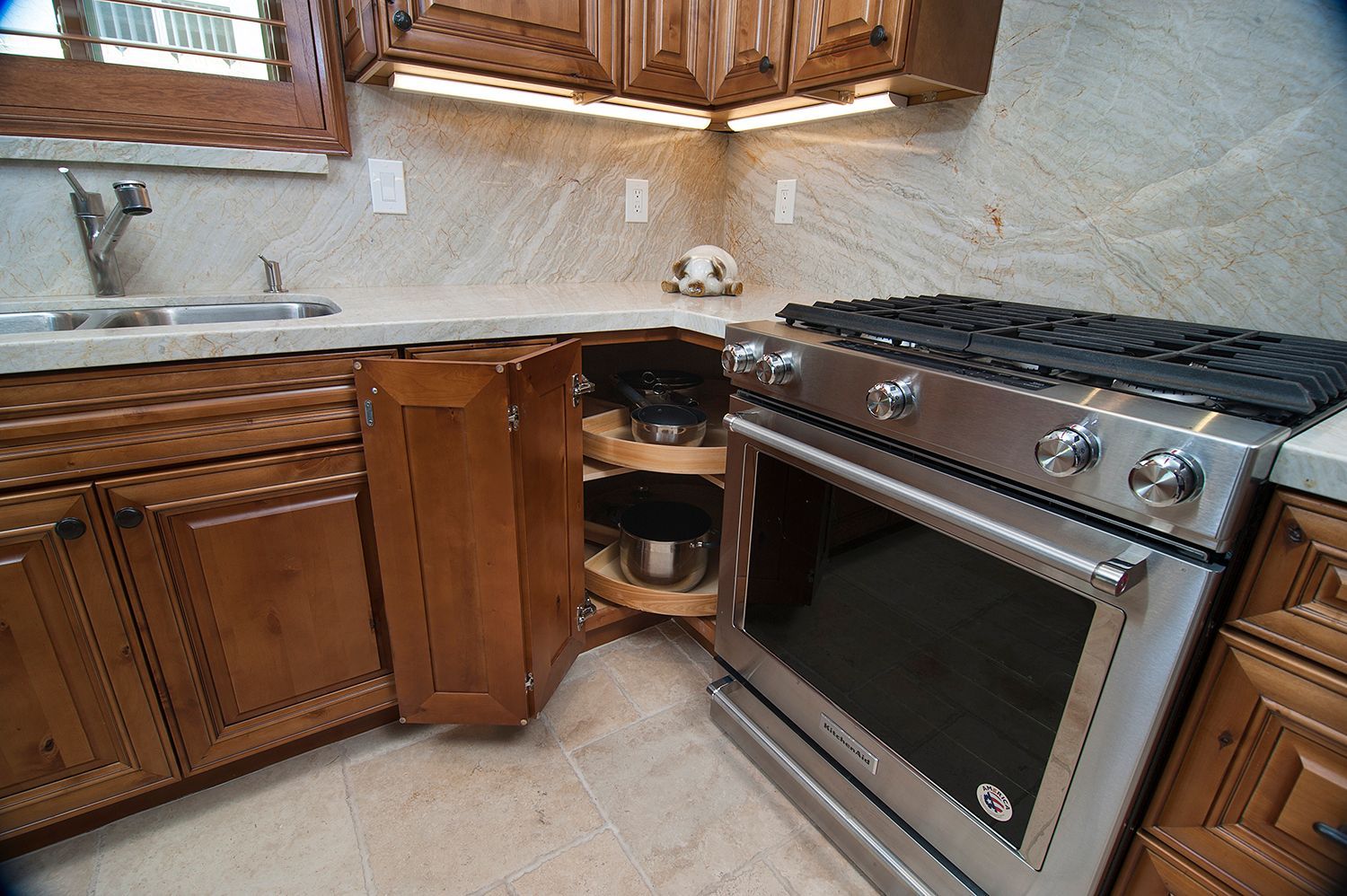 Kitchen corner cabinet with a pull-out lazy susan and a stainless steel oven.