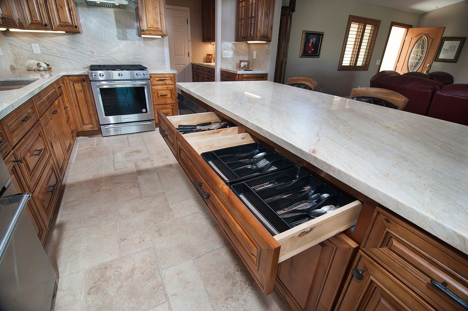Kitchen island with an open drawer revealing silverware organizers.