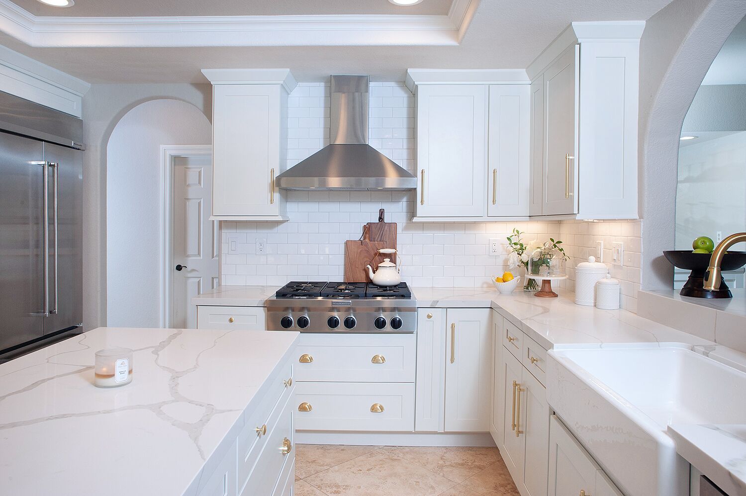 Bright white kitchen with an island and stainless steel appliances.